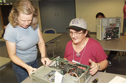 Trainer teaching a student how to work on a computer